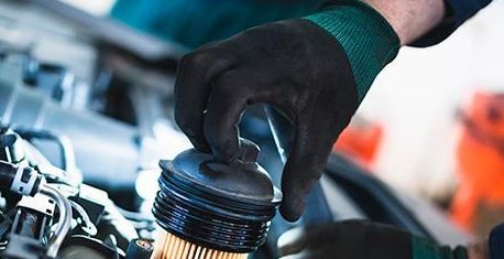 Gloved hand fitting a new oil filter