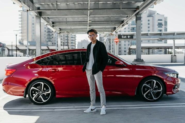 Michael R. standing next to his car