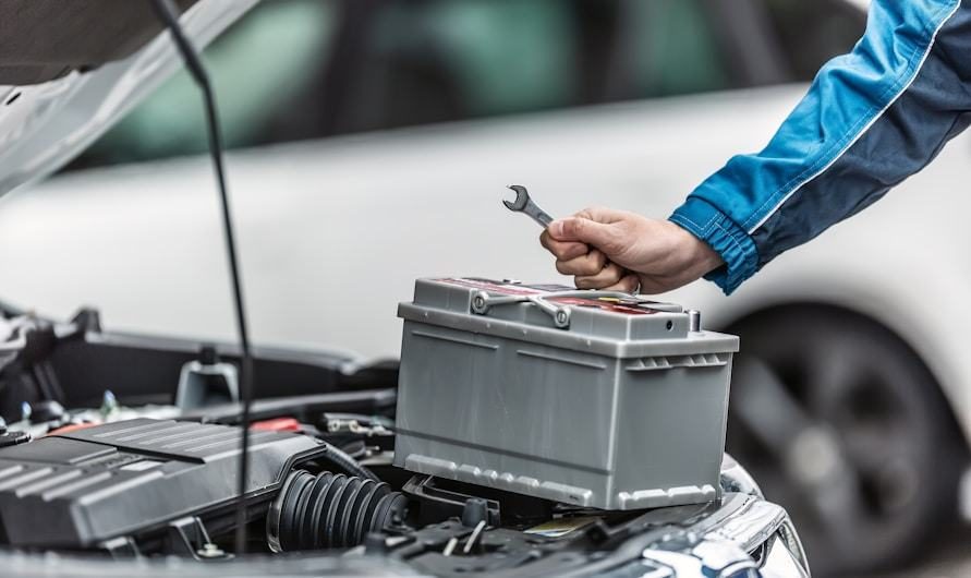 Technician fitting a new car battery
