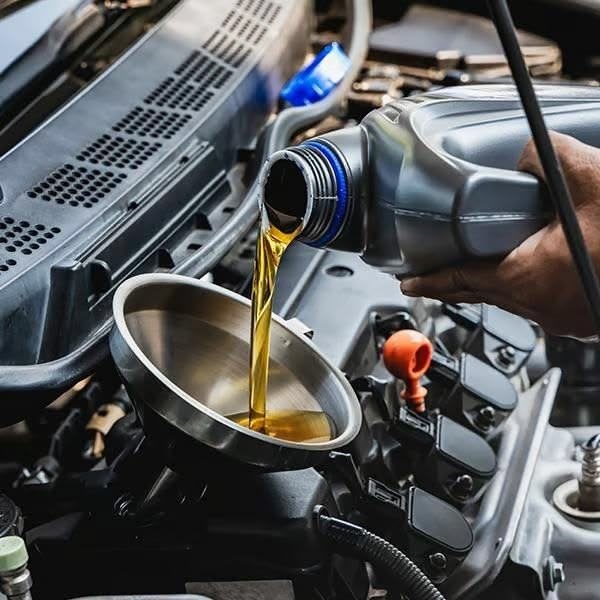 Fresh engine oil being poured through a funnel